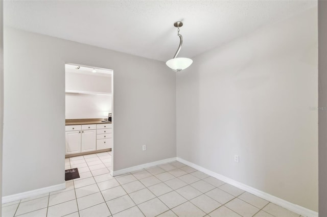 tiled spare room featuring a textured ceiling