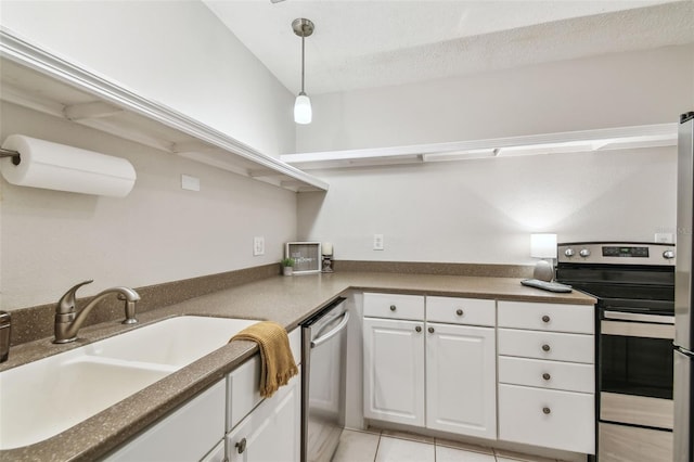 kitchen with stainless steel appliances, light tile patterned flooring, pendant lighting, white cabinets, and sink