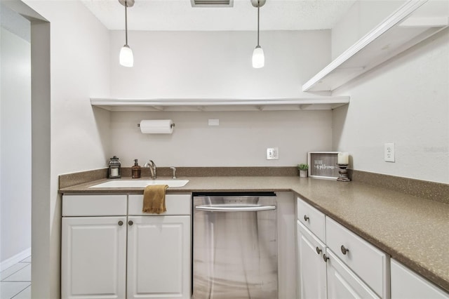 kitchen featuring white cabinetry, tile patterned flooring, hanging light fixtures, stainless steel dishwasher, and sink