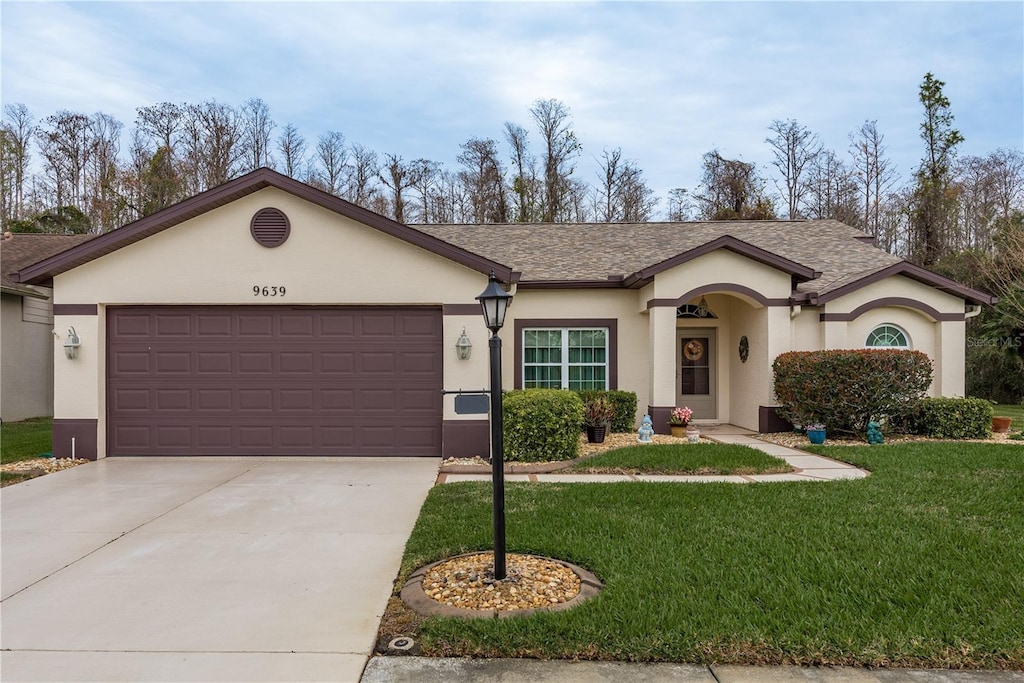 single story home featuring a garage and a front yard