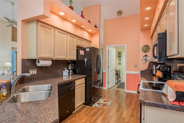 9639 Conservation Dr, New Port Richey, FL 34655 - kitchen featuring tasteful backsplash, black appliances, a towering ceiling, sink, and light brown cabinetry