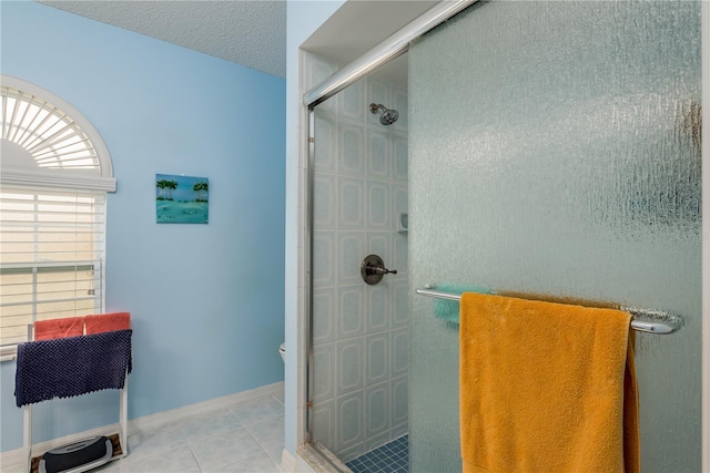 9639 Conservation Dr, New Port Richey, FL 34655 - bathroom featuring tile patterned floors, a shower with door, and a textured ceiling