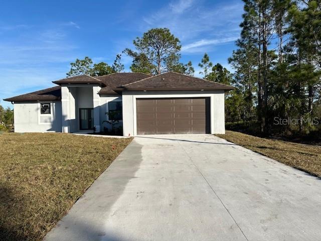 view of front of property featuring a front yard and a garage