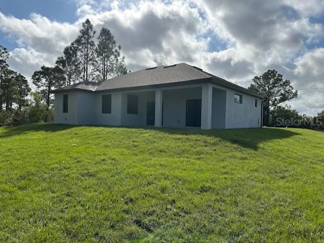 rear view of property featuring a lawn