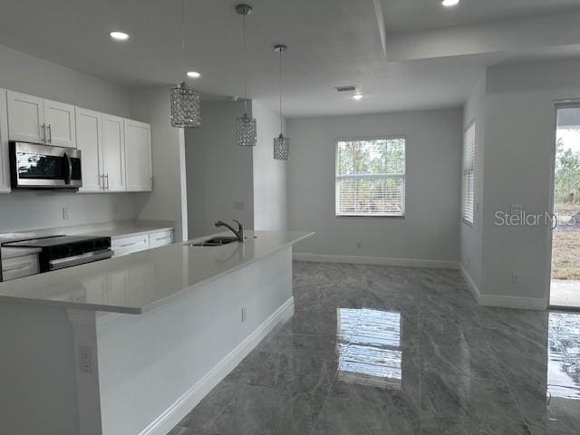 kitchen featuring plenty of natural light, an island with sink, white cabinets, pendant lighting, and electric range