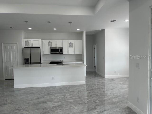 kitchen with sink, a center island with sink, white cabinets, and stainless steel appliances