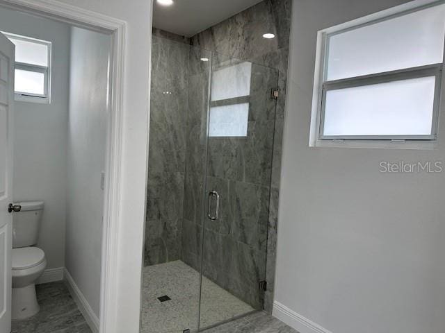 bathroom featuring an enclosed shower and toilet