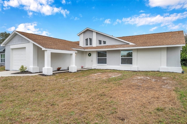 back of property featuring a garage and a lawn