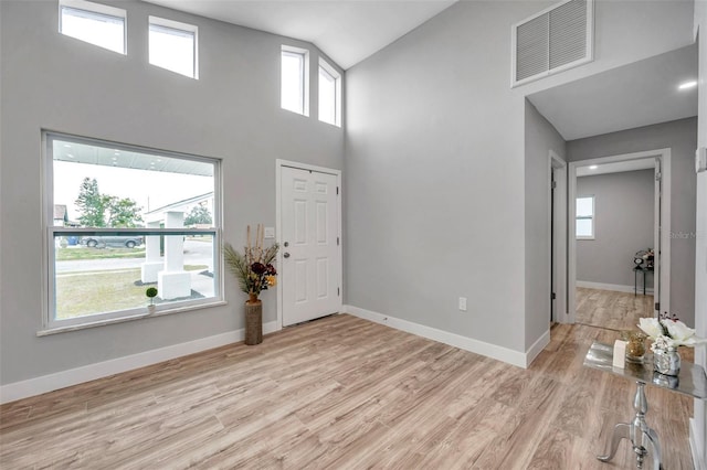 entrance foyer featuring high vaulted ceiling and light hardwood / wood-style flooring