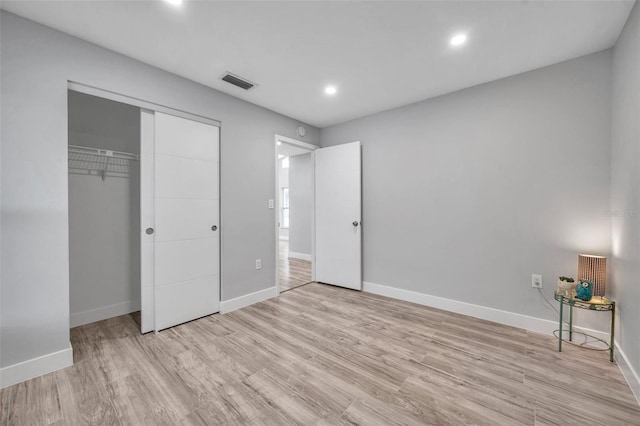 unfurnished bedroom featuring a closet and light wood-type flooring