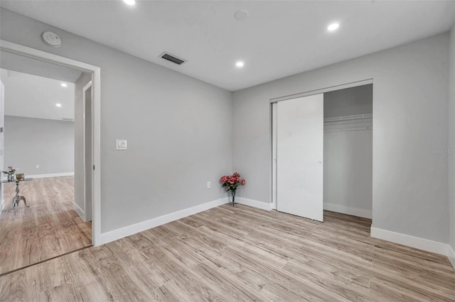 unfurnished bedroom with a closet and light wood-type flooring