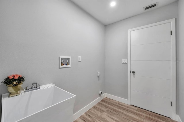 laundry area featuring sink, washer hookup, electric dryer hookup, and light hardwood / wood-style floors