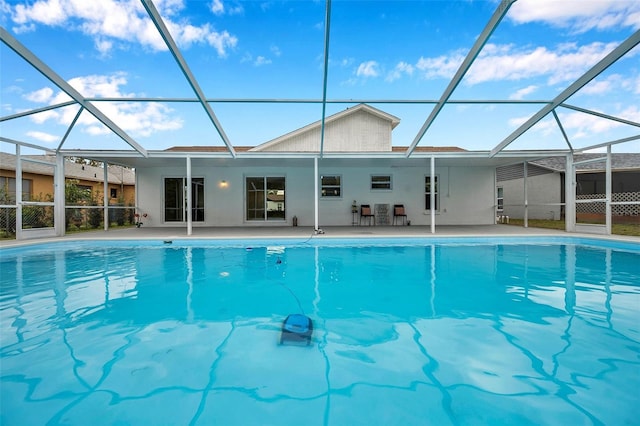 view of pool with glass enclosure and a patio