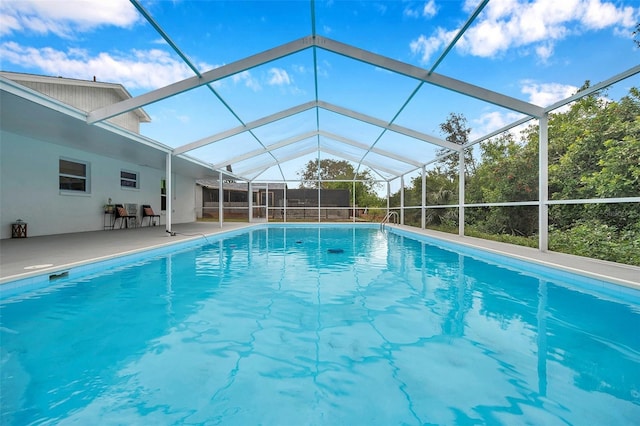 view of pool with a patio area and a lanai