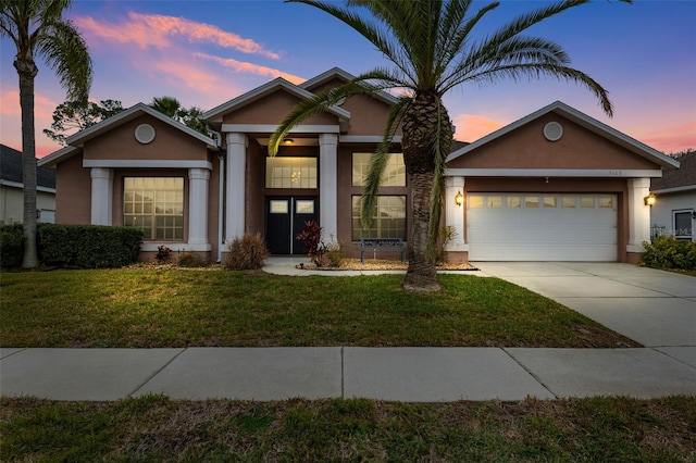 view of front of home featuring a garage and a lawn