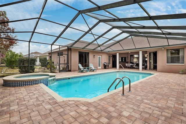 view of pool featuring a lanai, a patio area, and an in ground hot tub