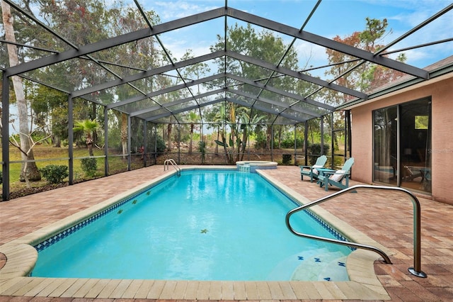 view of swimming pool featuring a patio, glass enclosure, and an in ground hot tub