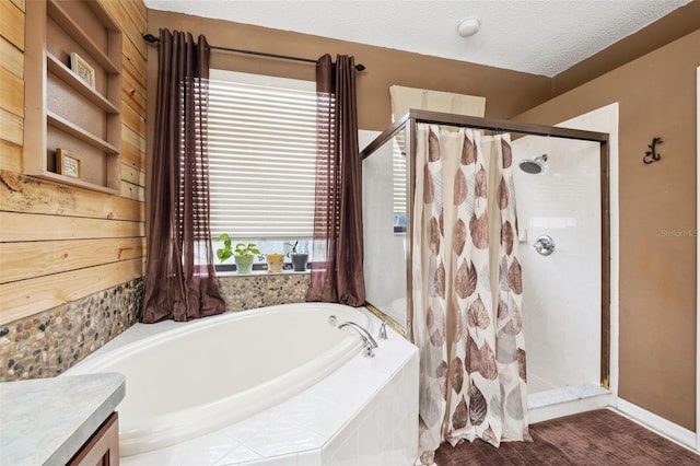 bathroom with vanity, a textured ceiling, and shower with separate bathtub