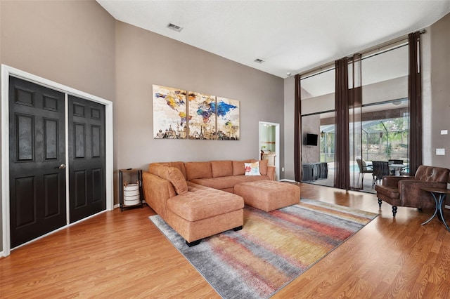 living room featuring hardwood / wood-style floors and a towering ceiling