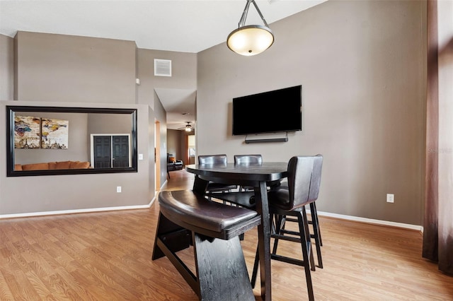 dining space with light hardwood / wood-style floors and ceiling fan