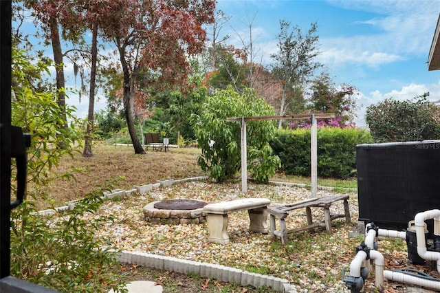 view of yard featuring central AC and a fire pit