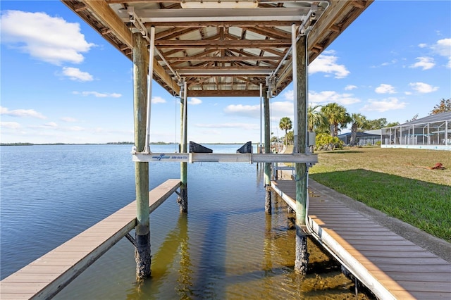 view of dock featuring a water view and a yard