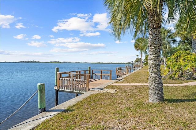 dock area with a yard and a water view