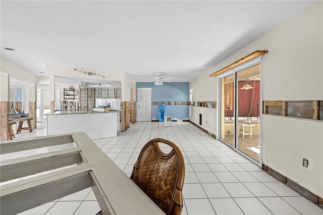 living room with ceiling fan, a wealth of natural light, and light tile patterned floors