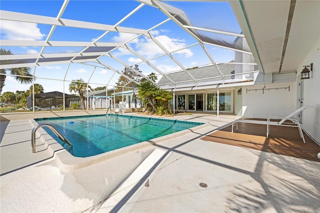 view of swimming pool with glass enclosure and a patio area