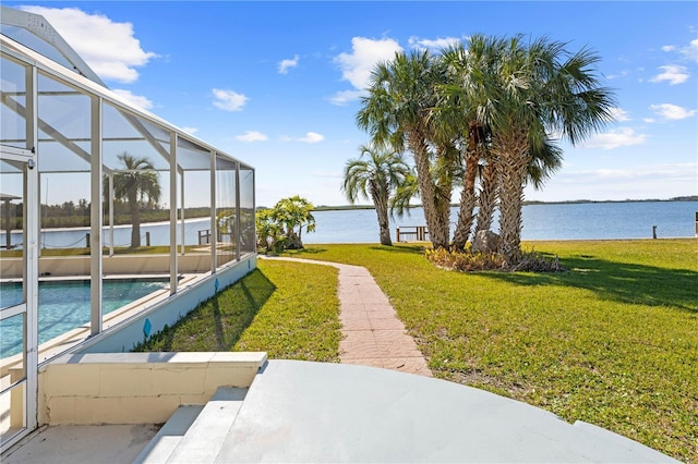 view of yard with glass enclosure and a water view