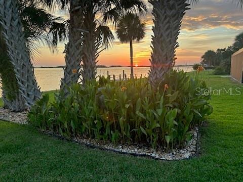 yard at dusk featuring a water view