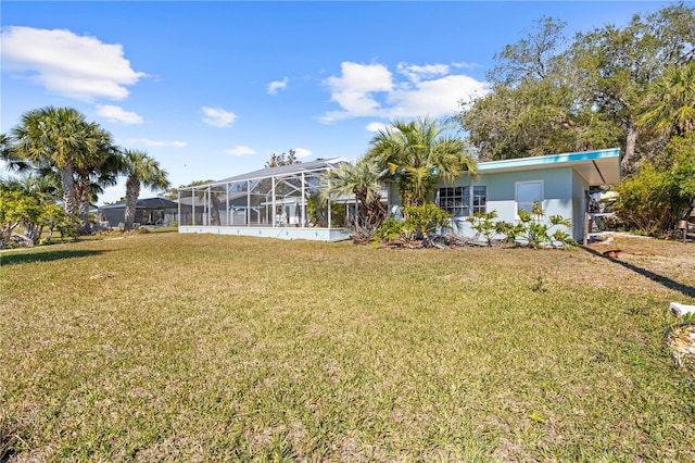 back of property with a lawn and glass enclosure