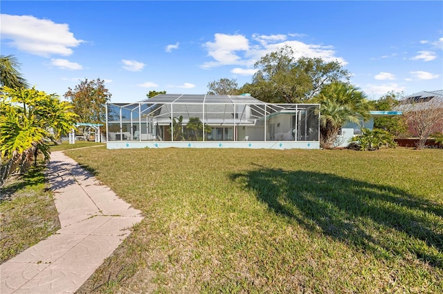 rear view of house with a lanai and a lawn