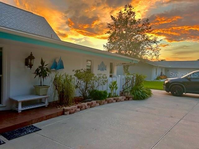 property exterior at dusk featuring a patio area