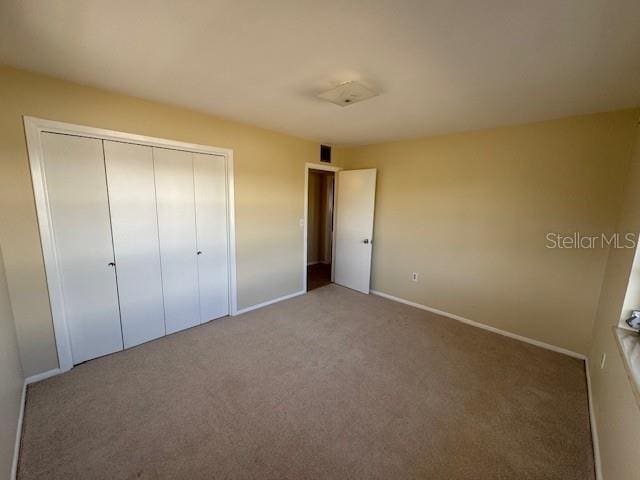 unfurnished bedroom featuring a closet and carpet floors