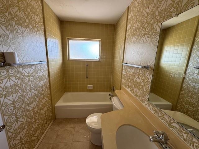 bathroom with tile patterned floors, tiled shower / bath combo, and toilet