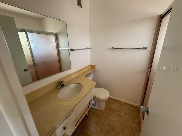 bathroom with toilet, vanity, and tile patterned floors