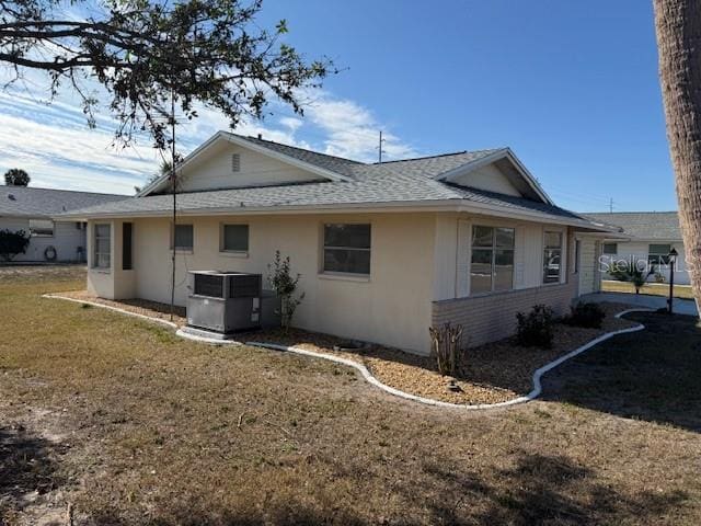 view of side of property featuring central AC and a lawn