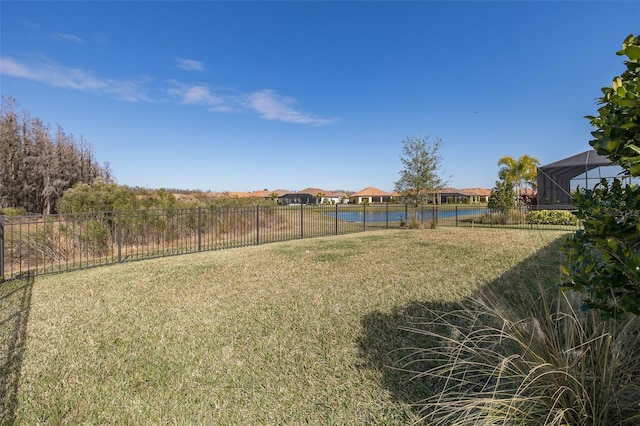 view of yard with a water view and a lanai