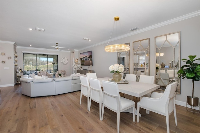 dining area with crown molding, light hardwood / wood-style floors, and ceiling fan with notable chandelier