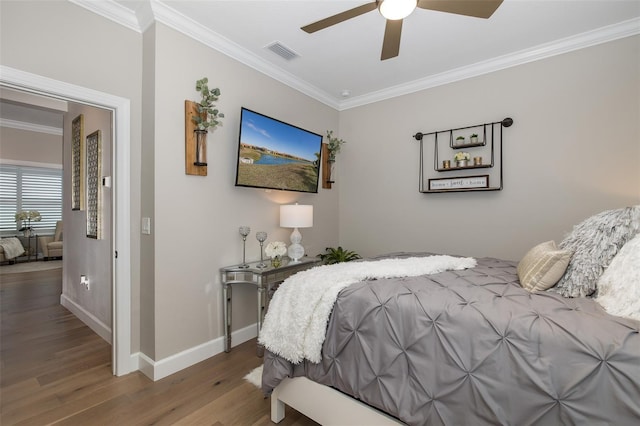 bedroom with hardwood / wood-style flooring, ceiling fan, and ornamental molding