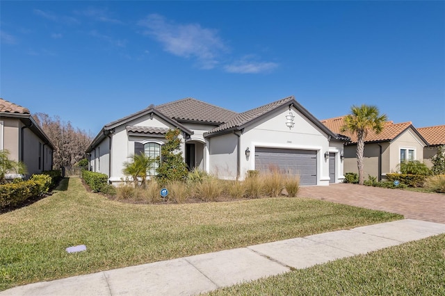 mediterranean / spanish house featuring a garage and a front lawn