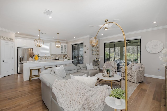 living room with ornamental molding and light hardwood / wood-style floors