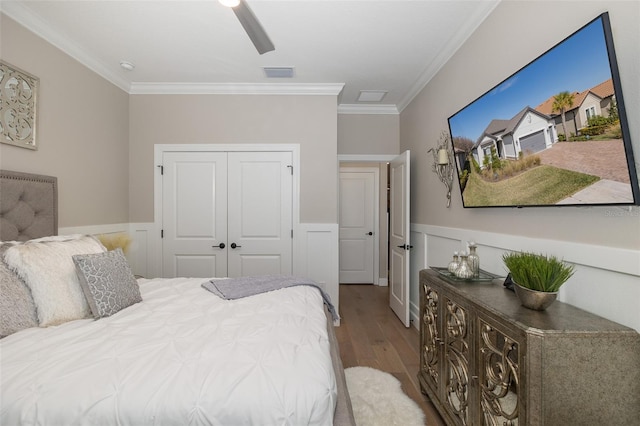 bedroom featuring crown molding, light hardwood / wood-style flooring, a closet, and ceiling fan