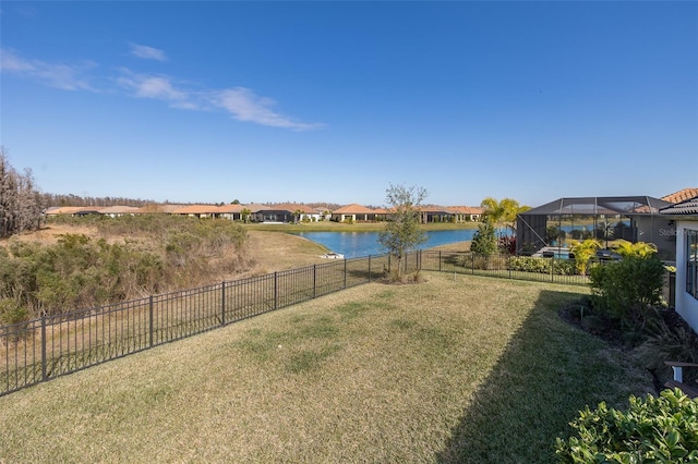 view of yard with a lanai and a water view