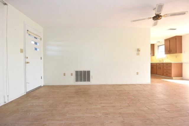 unfurnished room with ceiling fan, sink, and light hardwood / wood-style floors