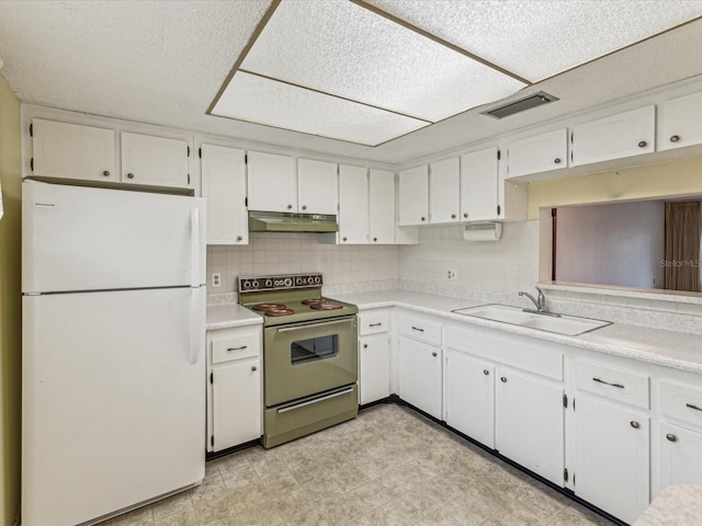 kitchen with sink, stainless steel range with electric stovetop, white cabinetry, decorative backsplash, and white fridge