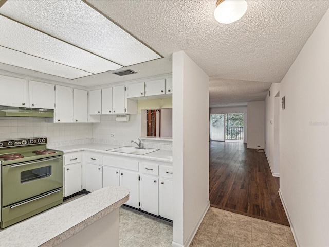 kitchen with range with electric cooktop, sink, white cabinets, backsplash, and a textured ceiling