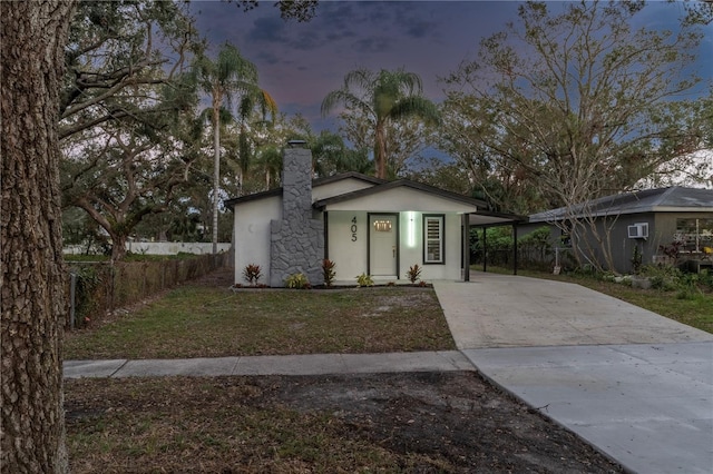 view of front of property with a lawn and a carport