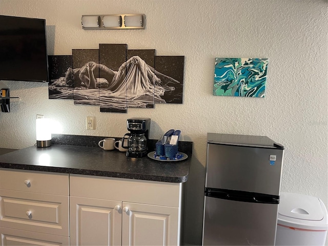 kitchen featuring white cabinetry and stainless steel fridge